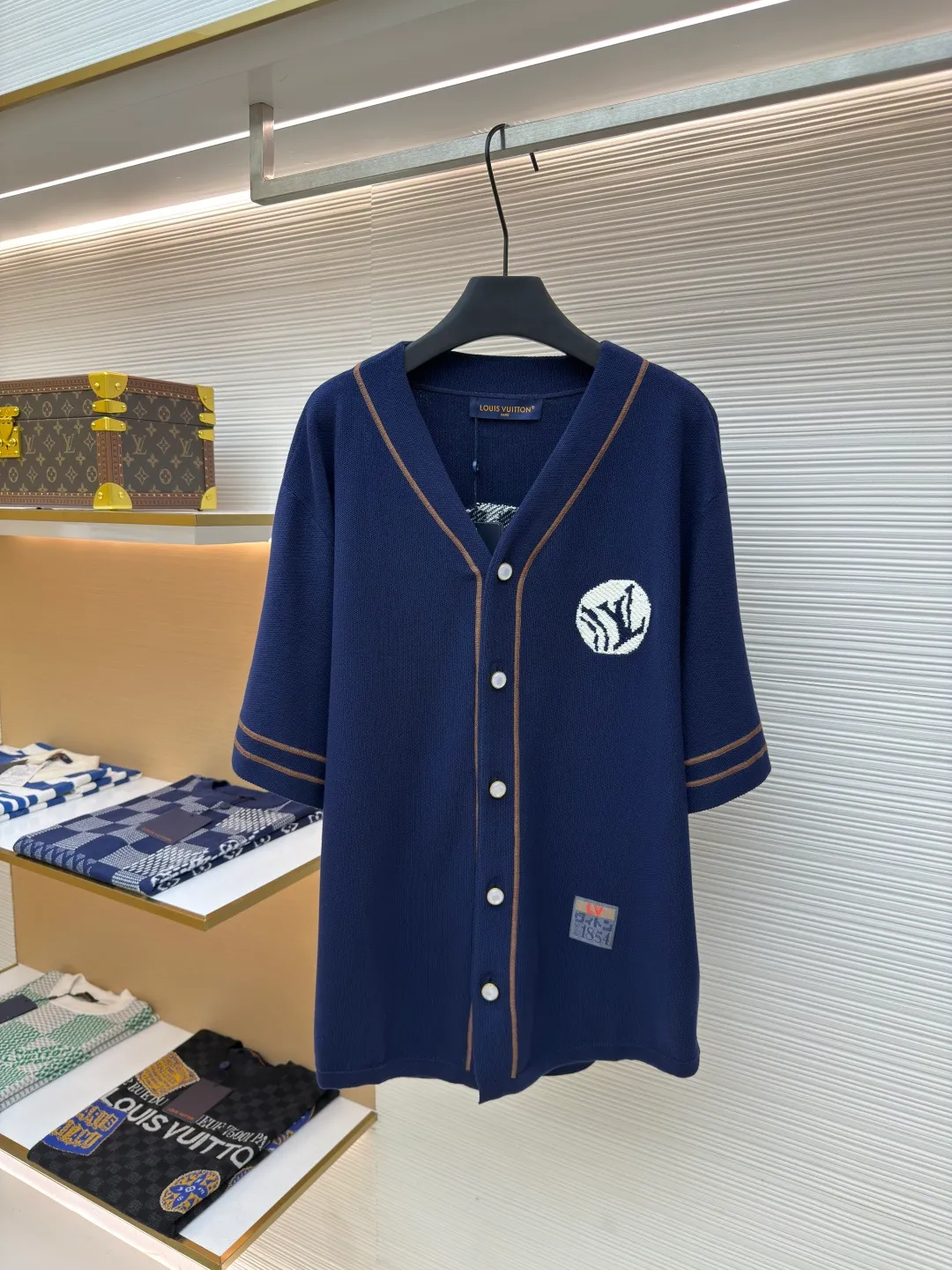 LOUIS VUITTON baseball knitted short-sleeved shirt ●Authentic product: Purchased and developed for 15999 ●Item number: 1680120-B65 ●Fabric: Customized cotton fabric ●Technology: Knitted production ●Version: loose fit ●Weight: about 530 grams ●Size: S-M-L-XL ●Description: Purchased YB pattern making, using imported custom-made cotton fabrics. The knitted texture is fine, uniform and high-end, and has good skin-friendliness; the white logo embroidery stitches before and after the embroidery are delicate; the embroidery threads are closely arranged, and the edges are smooth and regular. The three-dimensional effect is outstanding and increases brand recognition; the buttons are made of pearl material with a warm luster. The button hole position is manually positioned and opens and closes smoothly; the 1854 label in the lower left corner is neatly cut and has fine stitching; the label and the main body of the clothing are sewn firmly and evenly, which not only highlights the brand's historical heritage, but also becomes the finishing touch in the overall design! The overall routing is straight and delicate, the fabric is comfortable and soft, and the color is consistent without color difference. It can be matched with the same style to create a fashionable look and control various occasions. Customized accessories, complete three labels, the same style for men and women!